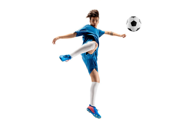 Young boy with soccer ball doing flying kick - Фото, изображение
