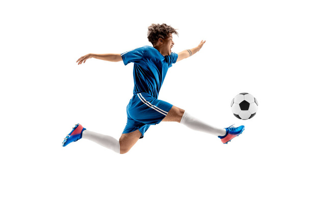 Young boy with soccer ball doing flying kick - Фото, зображення