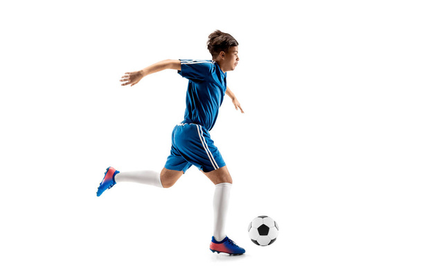 Young boy with soccer ball doing flying kick - 写真・画像