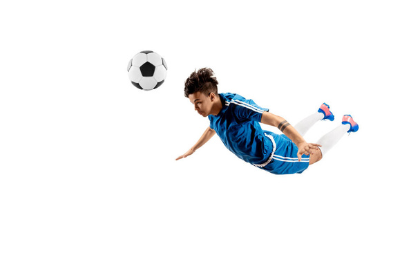 Young boy with soccer ball doing flying kick - Φωτογραφία, εικόνα