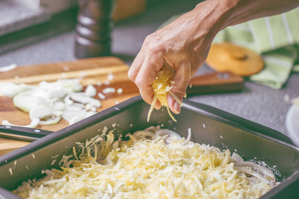 pişirme tepsisinde lezzetli ete rendelenmiş peynir ekleyerek kişinin kırpılmış atış  - Fotoğraf, Görsel