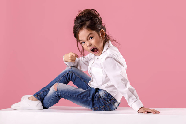 angry little child girl in white shirt with hairstyle - Foto, Bild