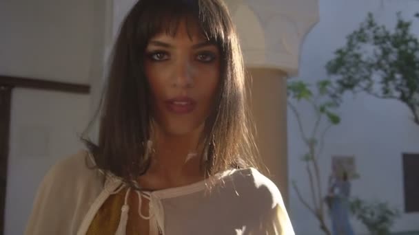 Όμορφη μαροκινή κορίτσι κουνώντας το λευκό μανδύα στο γραφικό Dar Si είπε Ριάντ στο Μαρακές κατά το ηλιοβασίλεμα - Πλάνα, βίντεο