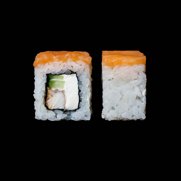 Sushi. Rollo de Filadelfia con salmón, anguila, pepino y queso crema, aislado en fondo negro
 - Foto, imagen