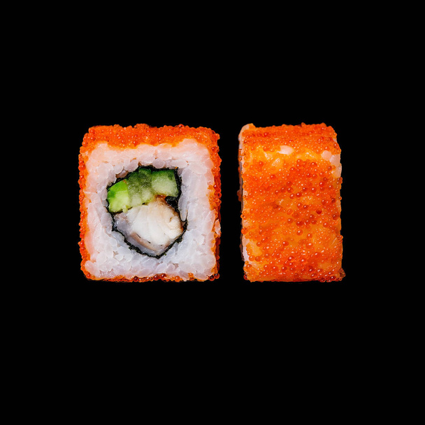Sushi. California roll met paling, avocado, komkommer en tobiko, geïsoleerd op zwarte achtergrond - Foto, afbeelding