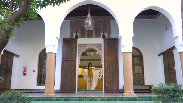 Piękna dziewczyna macha marokański jej biały płaszcz w malowniczej Dar Si powiedział Riyad w Marrakesz w czasie zachodu słońca. 4k Uhd - Materiał filmowy, wideo