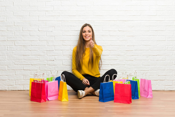 Fiatal lány sok kezet egy jó üzlet lezárásának bevásárló táskák - Fotó, kép