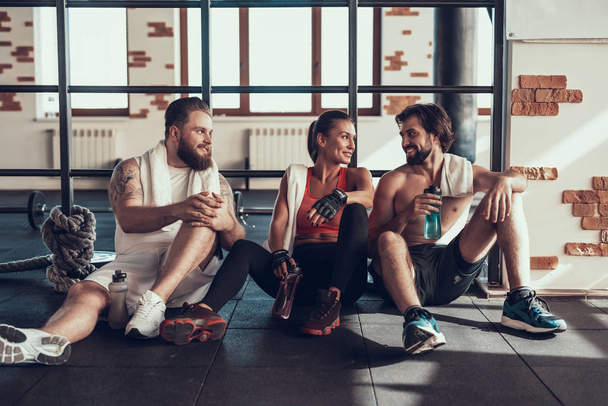 Two Guys And Girl Are Resting On Horizontal Bars. Training Day. Fitness Club. Healthy Lifestyle. Powerful Athlete. Active Holidays. Crossfit Concept. People Communication. Having Break. - Φωτογραφία, εικόνα