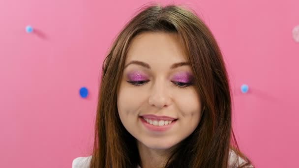 Portrait of attractive smiling caucasian ethnic young woman on crimson background - Felvétel, videó