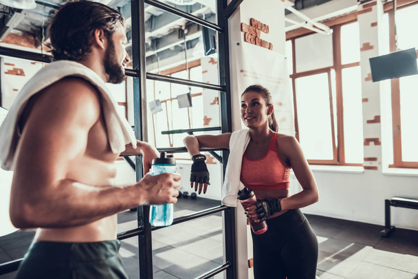 Man And Woman Are Talking During Break In Gym. Training Day. Fitness Club. Healthy Lifestyle. Powerful Athlete. Active Holidays. Crossfit Concept. Sport Towel. Half Naked. People Communication. - Photo, Image