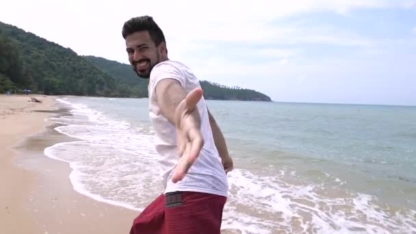 A young, handsome man is running along the beach on a tropical island. - Footage, Video