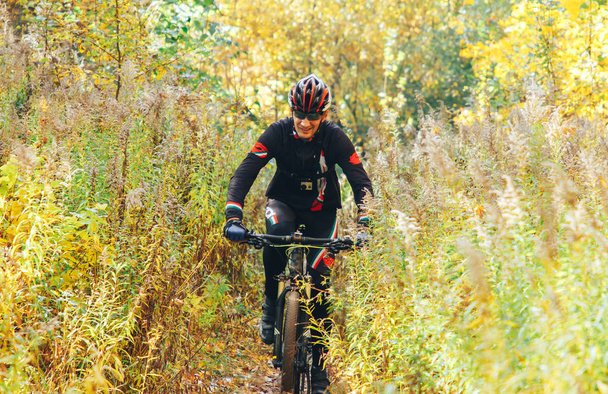 October 14, 2018 - Minsk, Belarus: 2018 Olympic Cross Country Cup XCO in Medvezhino man riding bicycle along forest trail - Zdjęcie, obraz