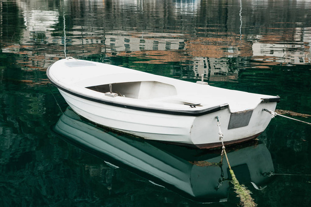 Bateau de pêche blanc vide en bois dans la mer près du rivage
 - Photo, image