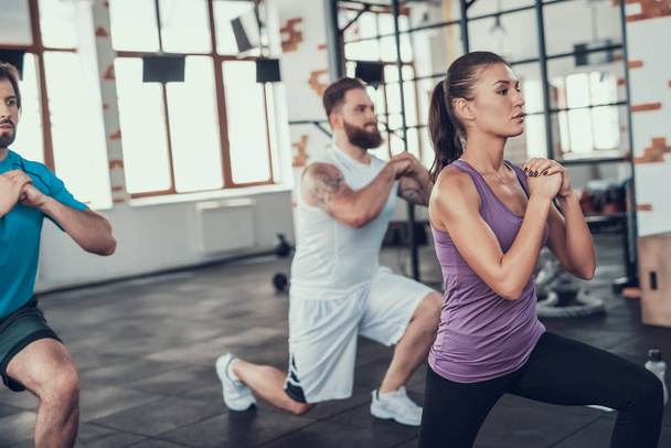 Girl And Two Guys Doing Lunge Exercises In Gym. Training Day. Fitness Club. Healthy Lifestyle. Powerful Athlete. Active Holidays. Crossfit Concept. Comfortable Sportswear. Legs Stretching. - Photo, Image