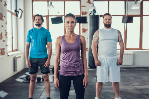 Female And Two Males. Sport Group. Posing On The Camera. Training Day. Fitness Club. Healthy Lifestyle. Powerful Athlete. Active Holidays. Crossfit Concept. Bright Gym. Hands Down. - Fotó, kép