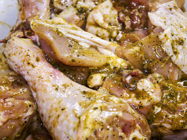 Kippenvlees gemarineerd met kruiden, neergelegd op een bakplaat, klaar om te bakken. - Foto, afbeelding