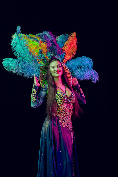 Beautiful young woman in carnival peacock costume - Фото, изображение