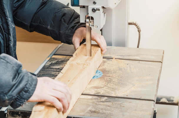 Mãos marceneiro corta um log na serra de fita. Carpintaria, produtos de madeira, trabalho, emprego
 - Foto, Imagem