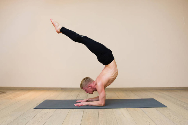 Sporty man practicing yoga on yoga class - Fotoğraf, Görsel