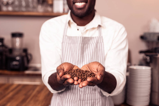 Selective focus of coffee beans in male hands - Foto, afbeelding