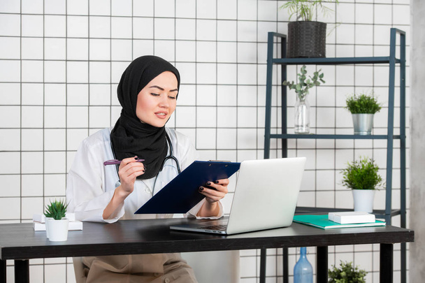 Dottoressa musulmana alla sua scrivania. Sfondo bianco - Foto, immagini