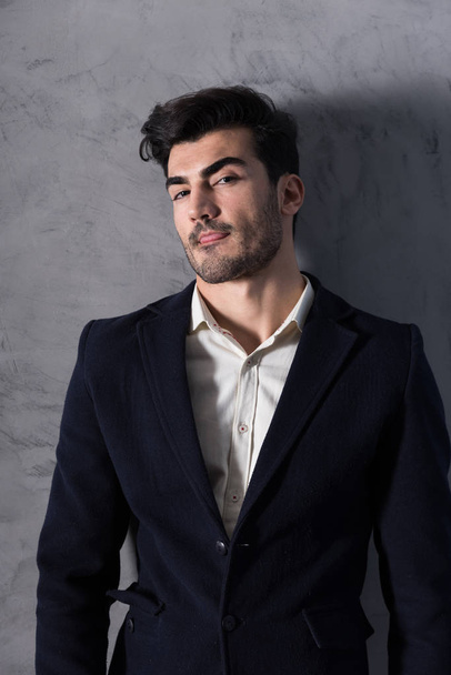 A confident young businessman in a black suit - Foto, imagen
