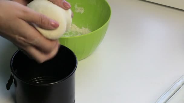 A woman puts a dough cake in a baking dish. Cooking bread at home. - Záběry, video