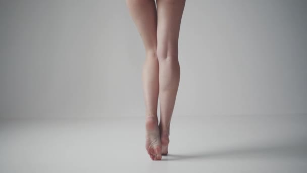 pernas femininas delgadas close-up. menina de pé na ponta dos pés em um fundo leve
 - Filmagem, Vídeo