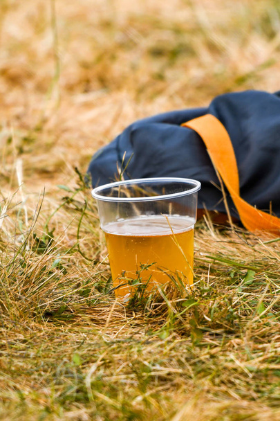 Coupe en plastique jetable de bière jetée sur l'herbe lors d'un événement en plein air
 - Photo, image