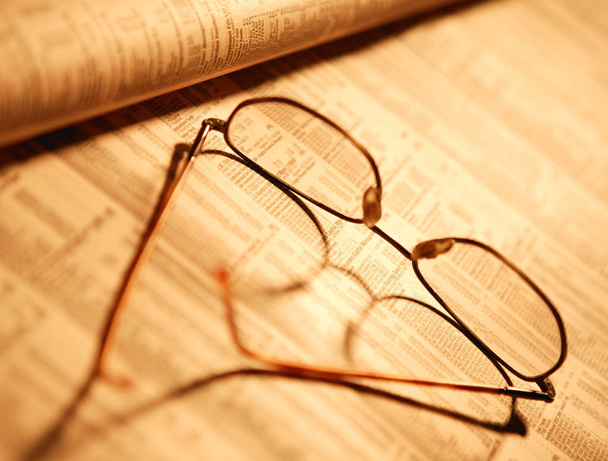 SPECTACLES ON FINANCIAL PAPER IN CLOSE UP - Foto, Imagen