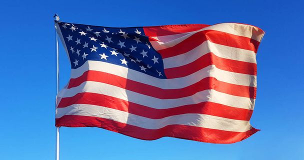 в День Благодарения флаг Соединенных Штатов Америки развевается ветром свободы в голубом небе и защищает всех американских граждан
 - Фото, изображение
