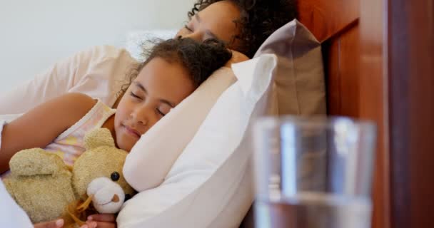 Front view of black mother and daughter sleeping in bedroom at home. Black girl holding teddy bear 4k - Video