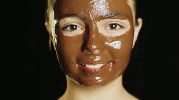 Çikolata bir yüz maskesi ile genç bir kız portresi - Video, Çekim