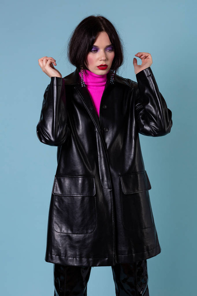 Fashion woman in leather jacket looking down in studio - Valokuva, kuva
