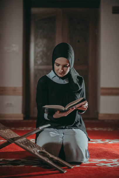 Muslim woman praying and reading Quran - Zdjęcie, obraz