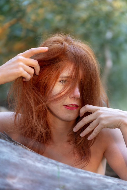 szép fiatal szexi vörös hajú nő élvezi, mosolyogva, boldogan játszik a gyönyörű dicsőséges vörös haját, függőleges. - Fotó, kép