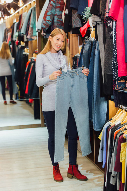 Woman with jeans and shopping in a fashionable clothing store. - Φωτογραφία, εικόνα