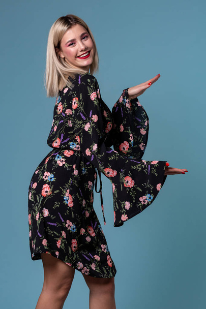 Obraz z Ładna Blondynka Kobieta w stroju wiosna Wyświetlono coś wielkiego z rąk - Zdjęcie, obraz