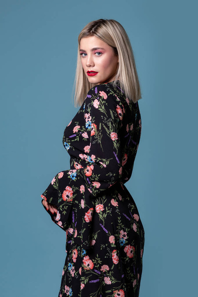 Young pretty sexy girl with blonde hair in a dark dress with flowers - Foto, Imagem