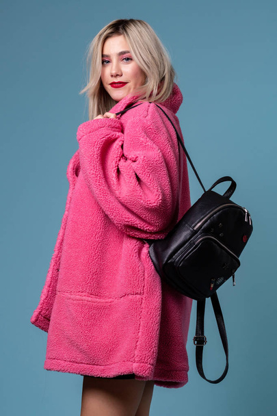 Fashion studio portrait of blonde girl with black backpack - Fotoğraf, Görsel