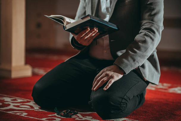 イスラム教徒の男性が祈りとの神聖な本を読む - 写真・画像