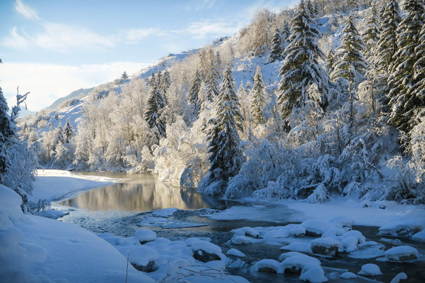 Beautiful winter wonderland scenery with snow on trees and frozen river in a valley in Graubuenden, Engadin - Foto, Imagen