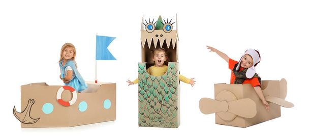 Little cute children playing with cardboard boxes on white background. Handmade toys and costumes  - Valokuva, kuva