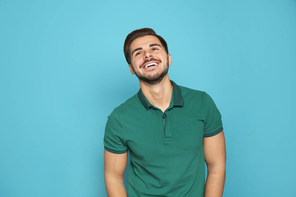Portrait of young man laughing on color background - Fotó, kép