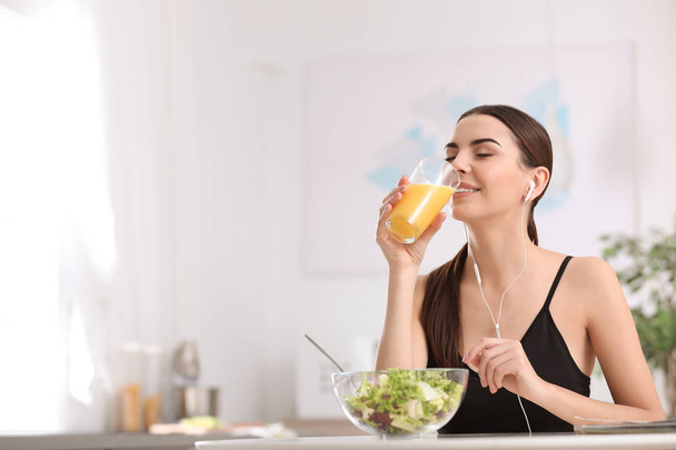 Young woman in fitness clothes having healthy breakfast at home. Space for text - Foto, Imagen