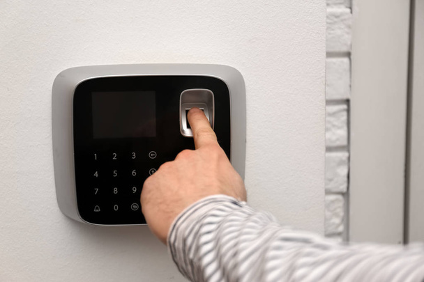 Man scanning fingerprint on alarm system indoors, closeup - Zdjęcie, obraz