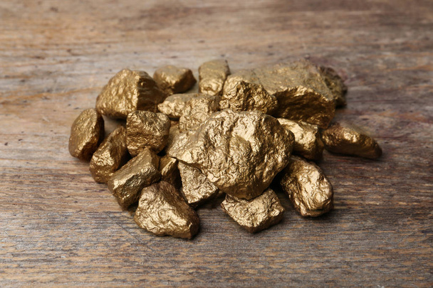Pile of gold nuggets on wooden background - Foto, Imagem