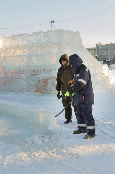 Instalador en el sitio de construcción de la ciudad de hielo mangueras de la pista a los niños
 - Foto, imagen