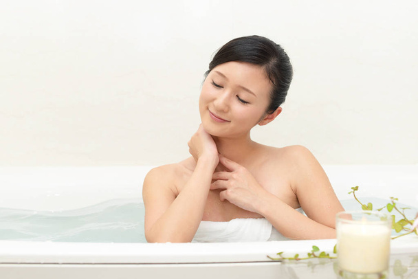 Beautiful young woman taking a relaxing bath - Φωτογραφία, εικόνα