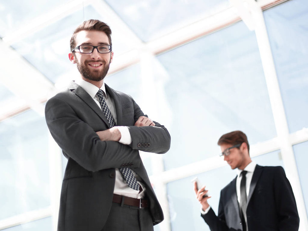 smiling businessman on the background of a modern office - Φωτογραφία, εικόνα
